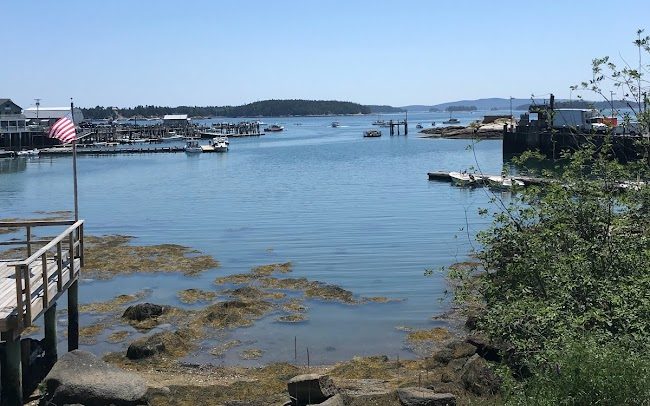 Walking through Stonington on West Main Street with glimpses of the harbor and ocean through the boutiques.  The American flag is waving in the breeze.  Haute Island is in the distance.  